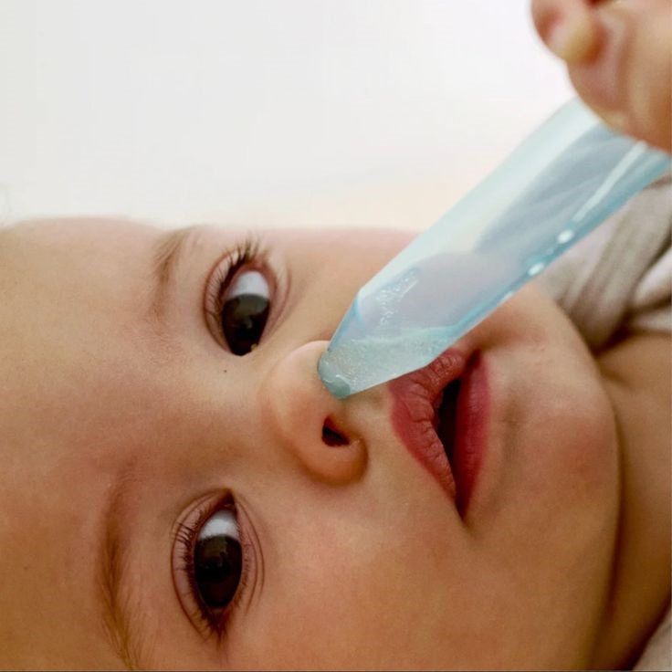 Aspirador nasal delicado sendo aplicado em bebê para higiene respiratória, principal cuidado no manejo da bronquiolite e infecções por VSR em bebês, ilustração de artigo por pediatra intensivista em Belo Horizonte